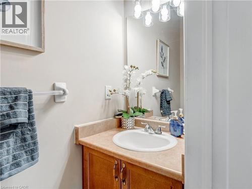 Bathroom vanity with a white drop-in sink, chrome faucet, and wood-finish cabinetry - 2229 Walkers Line Unit# 6, Burlington, ON - Indoor Photo Showing Bathroom
