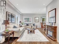 Spacious living area featuring wood-finish flooring, recessed lighting, and large windows - 