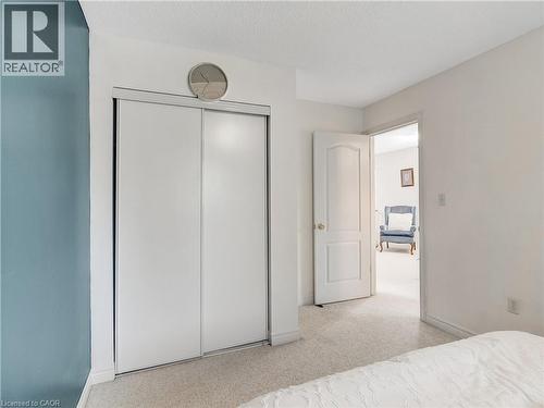 White sliding closet doors with track system - 2229 Walkers Line Unit# 6, Burlington, ON - Indoor Photo Showing Bedroom