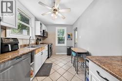 Kitchen featuring white cabinetry, light brown countertops, and stainless steel appliances - 