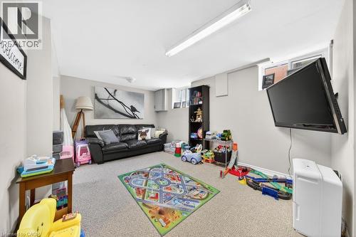 Lower-level recreational space featuring wall-mounted television and light gray wall paint - 420 Upper Gage Avenue, Hamilton, ON 