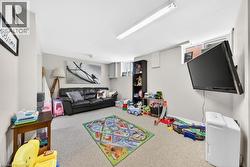Lower-level recreational space featuring wall-mounted television and light gray wall paint - 