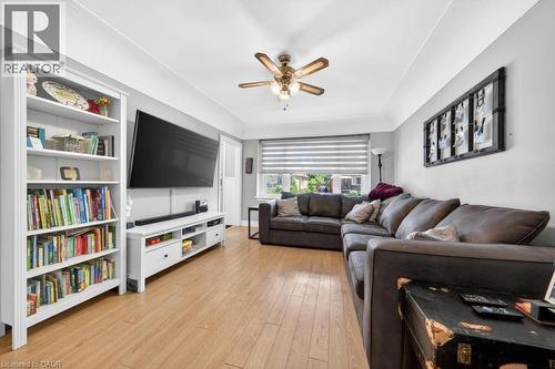 Wood-finish flooring throughout, featuring a ceiling fan with integrated lighting, and a window with horizontal blinds - 420 Upper Gage Avenue, Hamilton, ON 