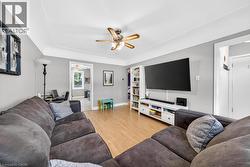 Living area featuring wood-finish flooring and a ceiling fan - 