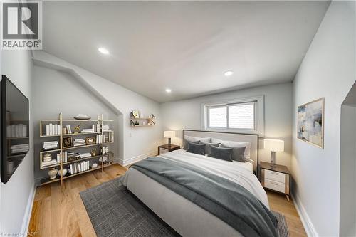 Spacious room featuring wood-finish . flooring, recessed lighting, and a white-framed window. virtually staged - 1062 Cannon Street E, Hamilton, ON 