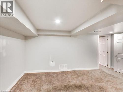 Finished room featuring neutral carpet, white walls, recessed lighting, and white trim - 229 Parkdale Avenue N, Hamilton, ON 