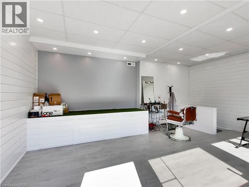 Spacious interior featuring wood-finish flooring, white shiplap walls, and recessed ceiling lighting - 229 Parkdale Avenue N, Hamilton, ON 