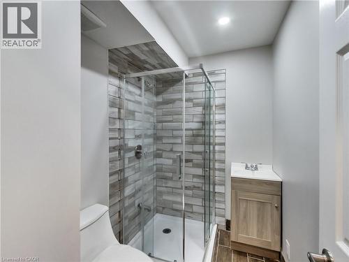 Contemporary bathroom with a glass-enclosed shower, featuring a tiled surround and a rain showerhead - 229 Parkdale Avenue N, Hamilton, ON 