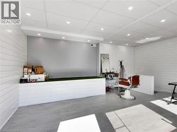 Spacious interior featuring wood-finish flooring, white shiplap walls, and recessed ceiling lighting - 