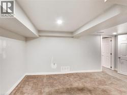 Finished room featuring neutral carpet, white walls, recessed lighting, and white trim - 