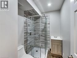 Contemporary bathroom with a glass-enclosed shower, featuring a tiled surround and a rain showerhead - 