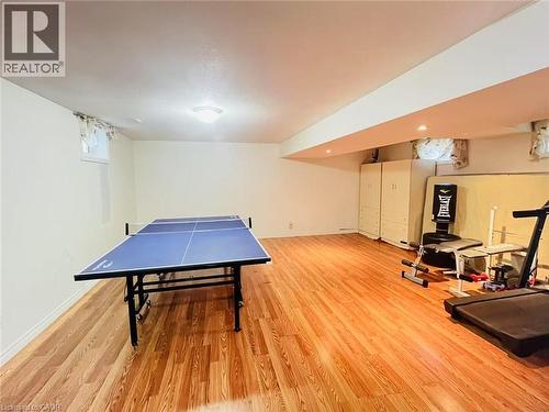 Spacious lower-level room featuring wood-finish flooring, recessed lighting, and bright white walls - 136 Hidden Creek Drive, Kitchener, ON 