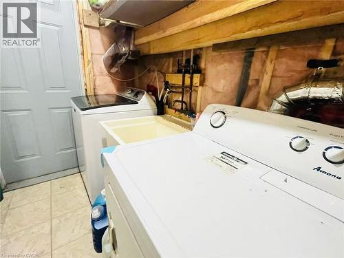 Utility area featuring a top-load washing machine, a freestanding dryer, and a utility sink - 136 Hidden Creek Drive, Kitchener, ON 