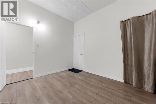 Room featuring wood-finish flooring, light neutral wall paint, and white baseboards - 1371 Main Street E, Hamilton, ON - Indoor Photo Showing Other Room