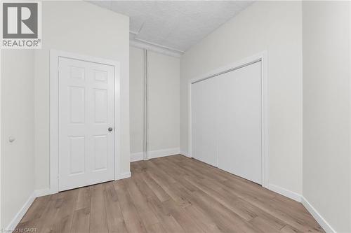 Neutral wall tones paired with wood-finish flooring - 1371 Main Street E, Hamilton, ON - Indoor Photo Showing Other Room