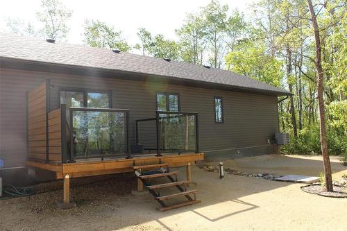 A view of the back of the house. Deck has privacy wall facing north, glass inserts and no maintenance railings. - 7 Dalvik Road, Gimli Rm, MB 