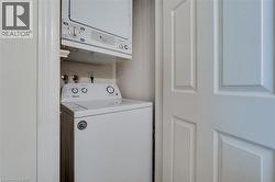 Dedicated laundry area featuring a stacked washer and dryer unit - 