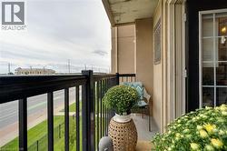Private balcony featuring a black metal railing and a glass-paneled entry door - 