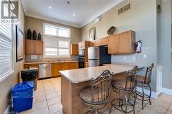 Kitchen area featuring light wood cabinetry, a light-colored countertop, and a tiled backsplash - 