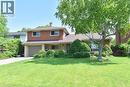 Split-level residence featuring a brick facade, integrated garage, and a lush front lawn - 372 Fennell Avenue W, Hamilton, ON 