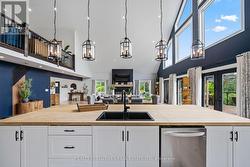 Five modern pendant lights over island - 