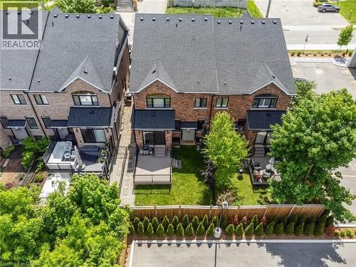Red brick townhome featuring a private backyard with a deck and established trees - 12 George Street, Waterloo, ON 