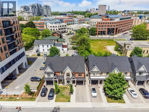 Row of townhouses featuring gabled roofs, stone and brick facades, and integrated single-car garages - 12 George Street, Waterloo, ON 