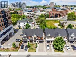 Row of townhouses featuring gabled roofs, stone and brick facades, and integrated single-car garages - 