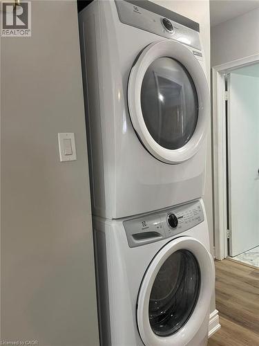 Space-saving stacked washer and dryer unit, featuring a white finish with grey control panels and front-loading doors - 102 Massey Avenue, Kitchener, ON 