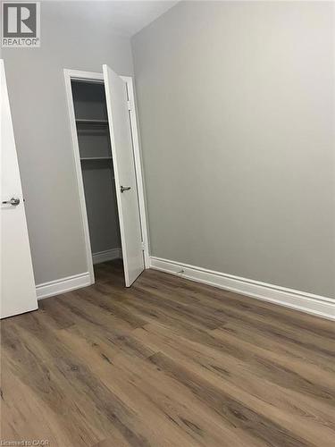 Wood-finish flooring throughout, featuring a neutral wall palette and white baseboards - 102 Massey Avenue, Kitchener, ON 