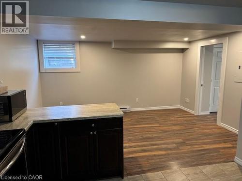 Open-concept living space with wood-finish flooring, recessed lighting, and a window - 113 Cornerbrook Crescent Unit# 2, Waterloo, ON 
