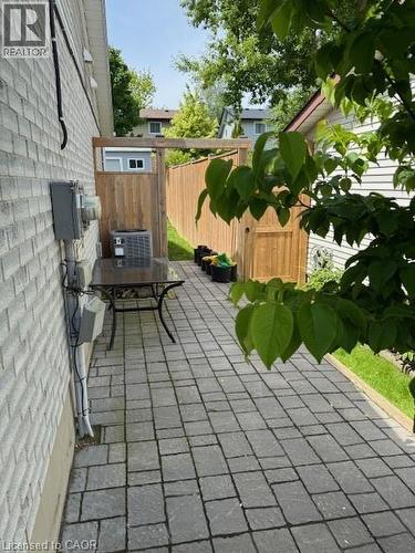 Paver patio with a full privacy fence and an external air conditioning unit - 113 Cornerbrook Crescent Unit# 2, Waterloo, ON 