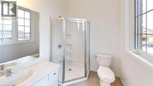 Bathroom featuring a glass-enclosed shower, white vanity with an integrated sink, broad wall mirror, and large window with grid pattern - 287 Rockledge Drive, Hamilton, ON 
