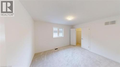 Carpeted room featuring light-colored walls, a single window, and a flush-mount ceiling light fixture - 287 Rockledge Drive, Hamilton, ON 