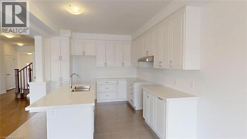 Modern kitchen featuring white shaker cabinetry, an integrated island with dual sinks, and light-toned countertops - 287 Rockledge Drive, Hamilton, ON 
