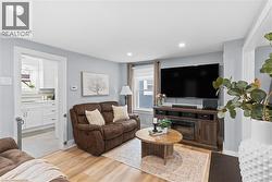 Light wood-finish flooring complements soft gray wall tones in this living space - 