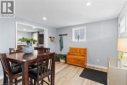 Inviting dining area featuring wood-finish flooring, light blue wall paint, and recessed lighting - 