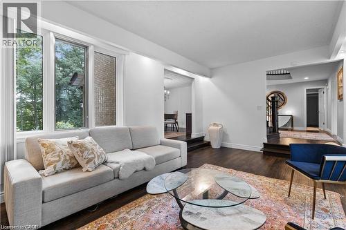 Bright living area featuring expansive windows, dark wood-finish flooring, white walls, recessed lighting, and a multi-level floor plan - 355 Edgehill Drive, Kitchener, ON 