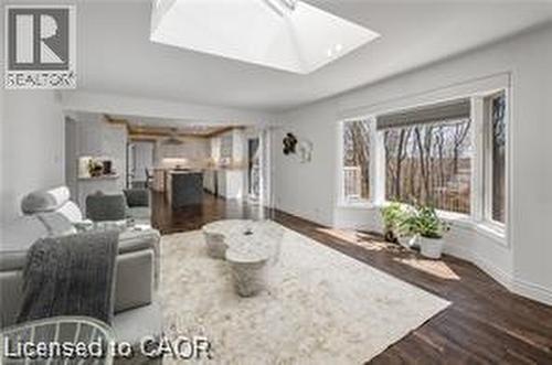 Spacious living area featuring dark wood-finish flooring, a large bay window, and a skylight - 355 Edgehill Drive, Kitchener, ON 