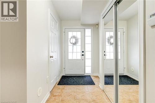 Foyer with tan tile flooring, white baseboards, and a white paneled door - 7 Sirente Drive Unit# 11, Hamilton, ON - Indoor Photo Showing Other Room