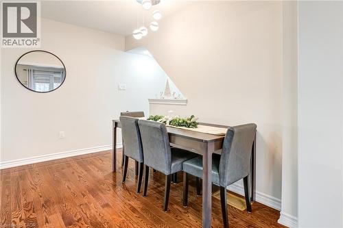 Dining area featuring rich wood-finish flooring, white baseboards, and a contemporary multi-bulb chandelier - 7 Sirente Drive Unit# 11, Hamilton, ON - Indoor Photo Showing Dining Room