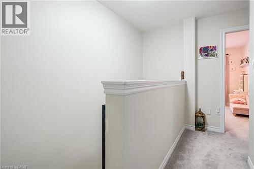 Upper-level hallway with light-toned walls, neutral carpeting, and a white balustrade with decorative molding - 7 Sirente Drive Unit# 11, Hamilton, ON - Indoor Photo Showing Other Room