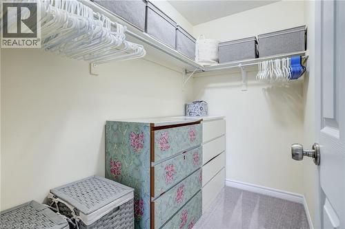 Walk-in closet featuring light-colored walls, carpet flooring, and a white interior door with a brushed nickel knob - 7 Sirente Drive Unit# 11, Hamilton, ON - Indoor