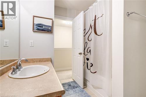Bathroom featuring a vanity with a drop-in sink, chrome faucet, and integrated backsplash - 7 Sirente Drive Unit# 11, Hamilton, ON - Indoor Photo Showing Bathroom