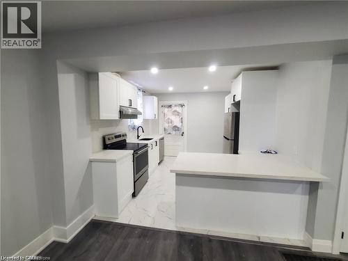Modern kitchen featuring white cabinetry, light-toned countertops, stainless steel appliances, and recessed lighting - 94 Brook Street, Simcoe, ON - Indoor Photo Showing Kitchen