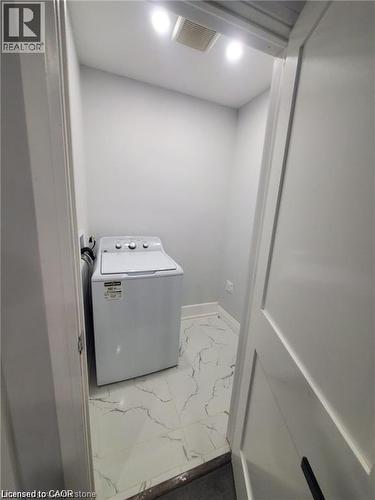 Dedicated laundry area featuring a top-load washing machine, recessed lighting, and white tile flooring with dark veining - 94 Brook Street, Simcoe, ON - Indoor Photo Showing Laundry Room