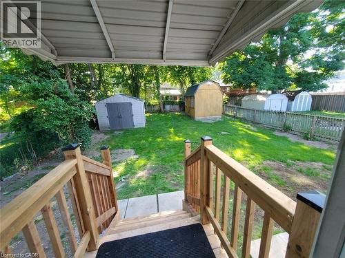 Expansive backyard featuring a manicured lawn, several storage sheds, and mature perimeter trees - 94 Brook Street, Simcoe, ON - Outdoor