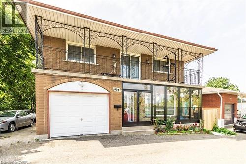 Brick exterior featuring an integrated garage with an arched surround - 404 Queenston Road, Hamilton, ON 