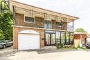 Brick exterior featuring an integrated garage with an arched surround - 404 Queenston Road, Hamilton, ON 