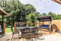 Expansive outdoor deck featuring wood decking, wood railings with black balusters, and a privacy fence - 